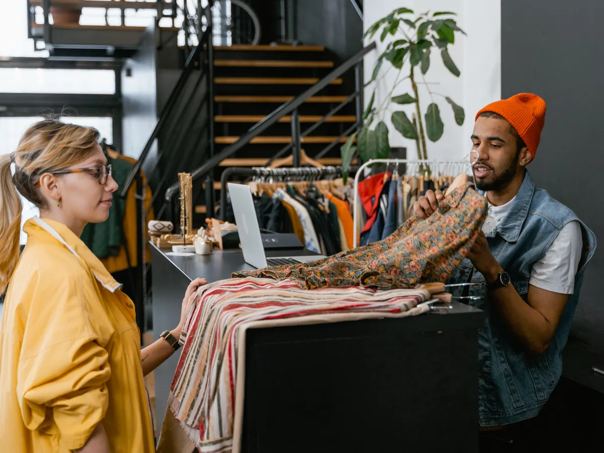 Une vendeuse accompagne une cliente au comptoir d’une boutique.